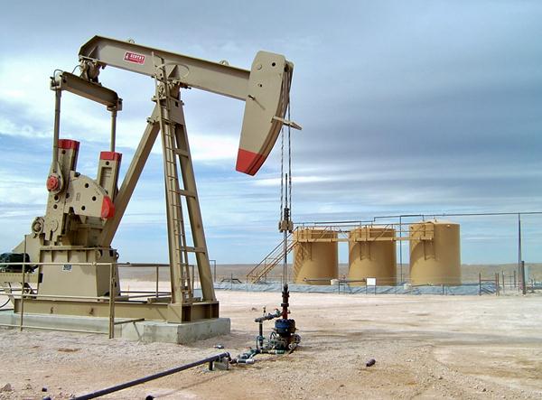 Pump Jack In Operation with Tank Battery as Back Drop